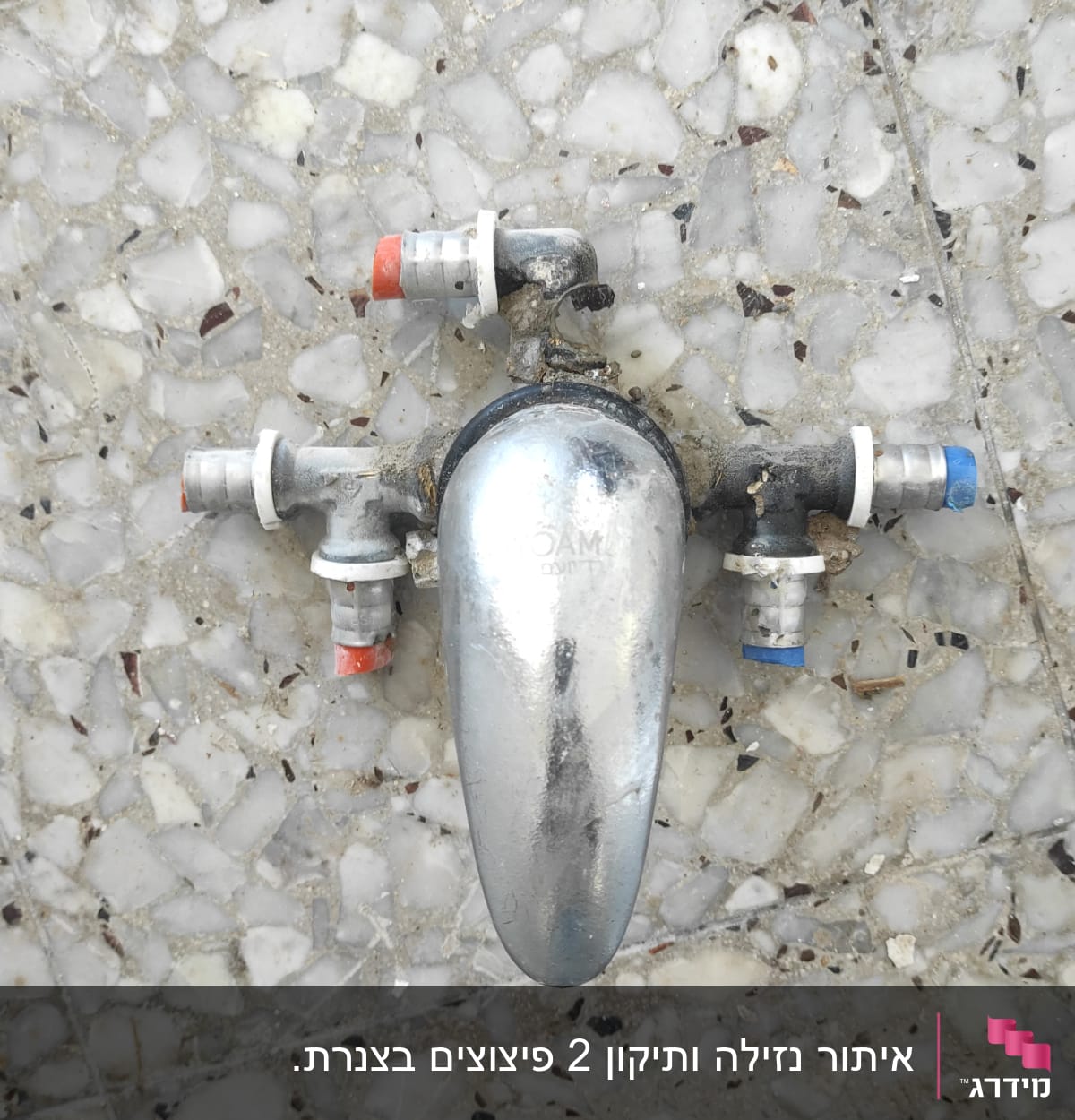 ברז מתכת עם חיבורים צבעוניים על רצפה
